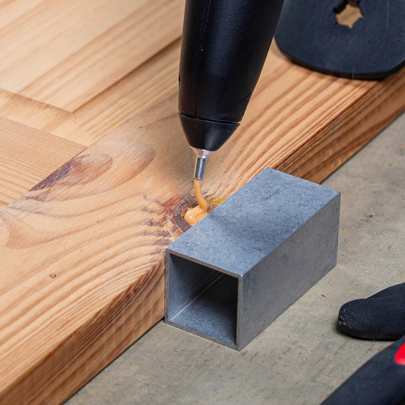 Tec 806-12 glue gun applying adhesive to a wooden surface using Knottec repair glue.