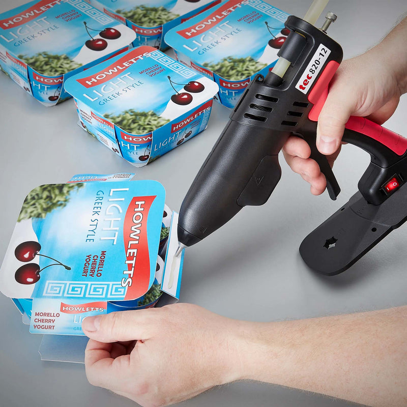 Worker sealing a yogurt package using TEC Bond 214B with a hot glue gun